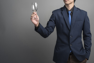 Close up of businessman in blue suit celebrating victory on gray
