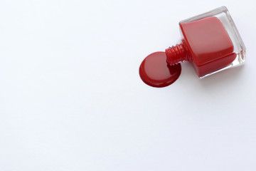 Red nail polish on a white background with space for text