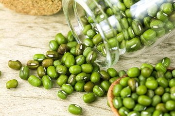close up green mung beans in wooden spoon on wood plate