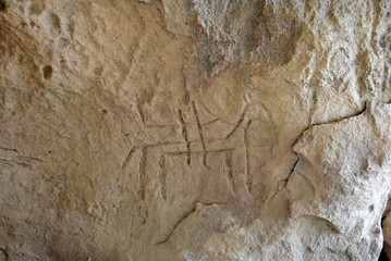 Prehistoric rock carving (petroglyph) in Gobustan, Azerbaijan, depicting human figure riding a horse.