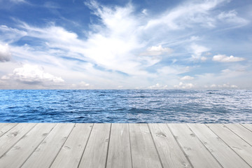 Obraz premium Sea wave and empty wooden floor on blue sky background.