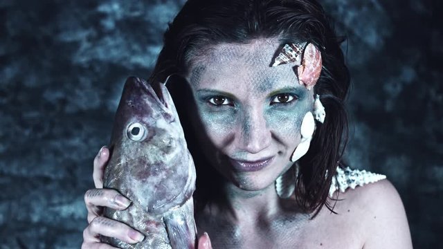 4k Halloween Shot of a Horror Woman Mermaid Petting a Real Fish