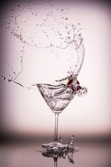 Beautiful water splash in martini glass from a cherry