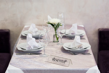 Empty glasses and dishes set in an interior new luxury restaurant with covered tables