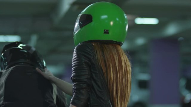 Girl wearing a bike helmet and sitting behind the biker and they riding on a bike.Shot on RED EPIC Cinema Camera in slow motion.