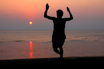 Fototapeta premium sunset and silhouette of a dancer in the beach