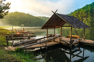 Wooden house and bridge over the lake in the morning