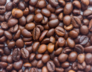 Naklejka premium Close up beans on a white background. Coffee on the entire screen for the background. Roasted coffee beans brown. Lots of coffee in high definition.