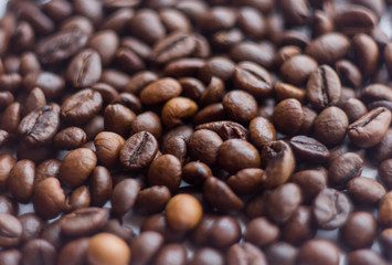 Close up beans on a white background. Coffee on the entire screen for the background. Roasted coffee beans brown. Lots of coffee in high definition.