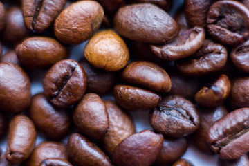 Close up beans on a white background. Coffee on the entire screen for the background. Roasted coffee beans brown. Lots of coffee in high definition.