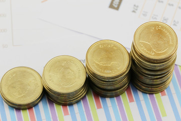 bar graph of Gold coins on paper business documents.