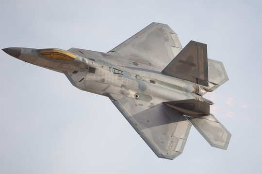 Fototapeta F-22 Raptor in a turn, with afterburner on
