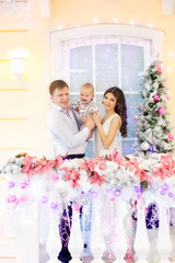 Fototapeta na wymiar Happy family with child son lying near Christmas tree