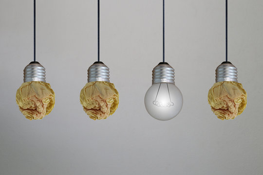 Ceiling lamp designed by crumpled paper on gray concrete wall.