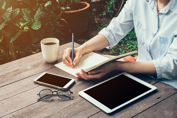 Young business woman hand with pencil writing on notebook. Woman
