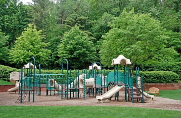 Children's schoolyard playground surrounded by trees. Horizontal.