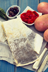 cod fish with red pepper and potato on wooden background