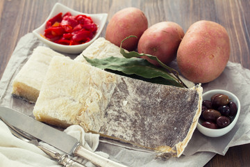 cod fish with potato and red pepper on wooden background