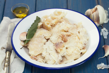 dry cod fish on dish on wooden background