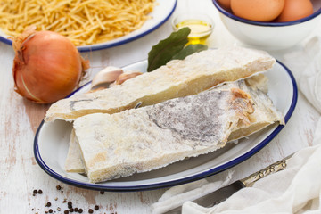 salted codfish on dish with potato and onion