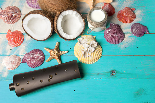 Spa coconut products and beach accessories on turquoise wooden boards