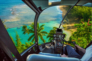 Helicopter cockpit flies in Kee Beach, Kauai, Hawaii, United States, with pilot arm and control board inside the cabin. © bennymarty