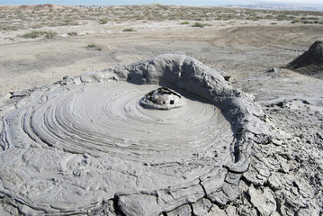 Fototapeta na wymiar Close-up of exploding bubble of mud in crater of mud volcano in Gobustan, Azerbaijan.