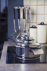 Stainless steel cooking pot on a stove and kitchenware