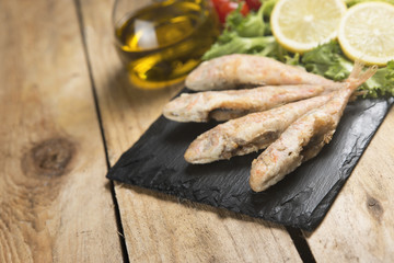 Fried red mullet fish served on a plate slate