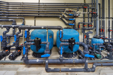 A mechanical electrical pump room showing a series of complex pipe works, pumps and valves