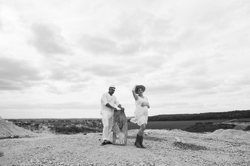 Pregnant woman and man sitting on rock