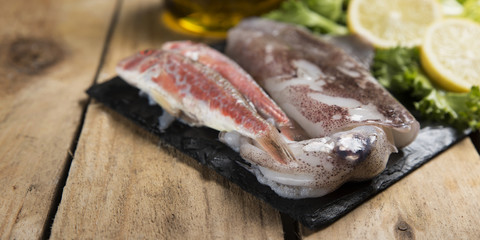 Fresh squid and red mullet fish served on a slate plate