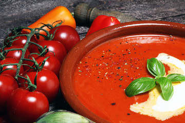 Tomato, red pepper soup, sauce with olive oil, rosemary and smoked paprika on a wooden background.