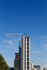 Building crane and construction site under blue sky.