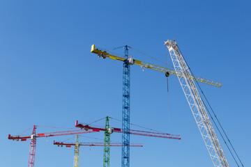 modern construction cranes in front of blue sky.