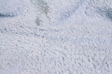 Closeup view of blue towel. Fluffy white background