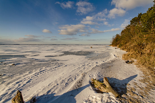 Gefrorener See mit Ufer Eis und Sonne