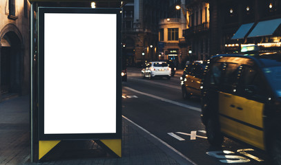 Blank advertising light box on bus stop, mockup of empty ad billboard on night station, template banner on background city street for text in Barcelona, afisha board and headlights of taxi cars