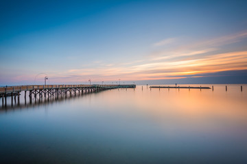Long exposure of the pier and Chesapeake Bay at sunrise, in Nort - obrazy, fototapety, plakaty