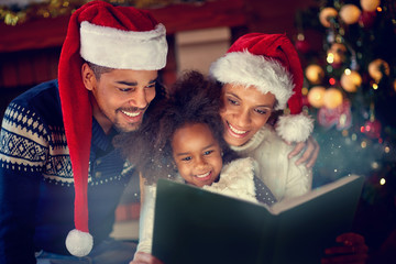 Young afro American family together reading Christmas fairytales
