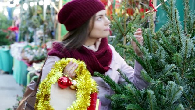 Happy woman   buying Christmas tree in market 