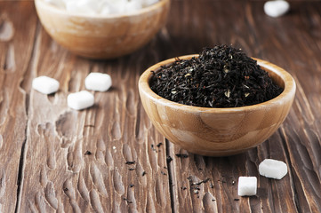 Raw tea and white sugar on the wooden table