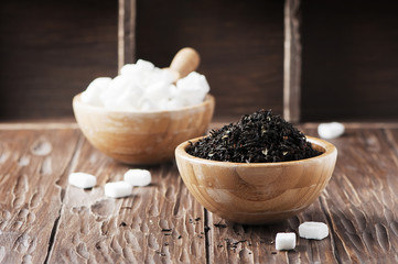 Raw tea and white sugar on the wooden table