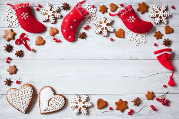 Christmas background with gifts in red socks, cookies, berries and snowflakes