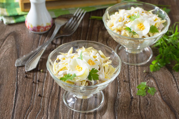 Festive salad with pickled herring, cheese and egg. Appetizer on