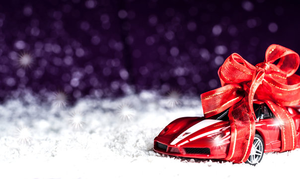 Small Car With A Decorative Bow In Snow