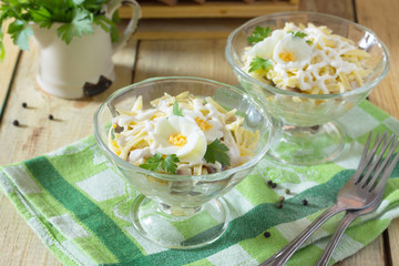 Salad with pickled herring, cheese and egg. Appetizer on a festi