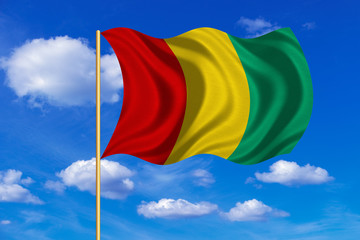 Flag of Guinea waving on blue sky background
