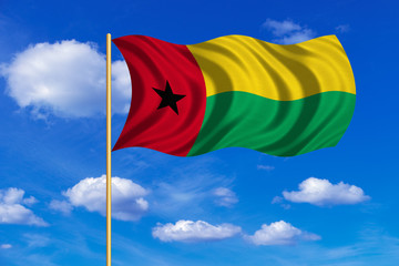 Flag of Guinea-Bissau wavy on blue sky background