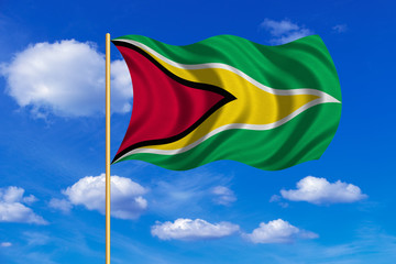 Flag of Guyana waving on blue sky background